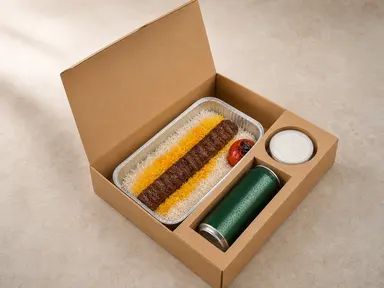 Open kraft Catering Toronto box with koobideh, saffron rice, sauce, and a drink